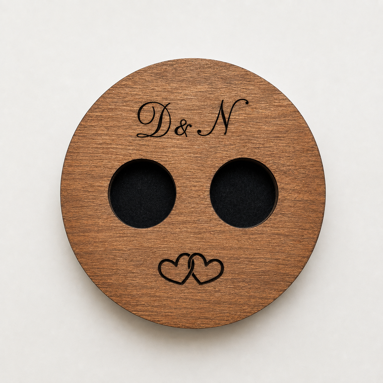 Verso de suporte para alianças em madeira personalizado com iniciais gravadas e encaixes para duas alianças de casamento.