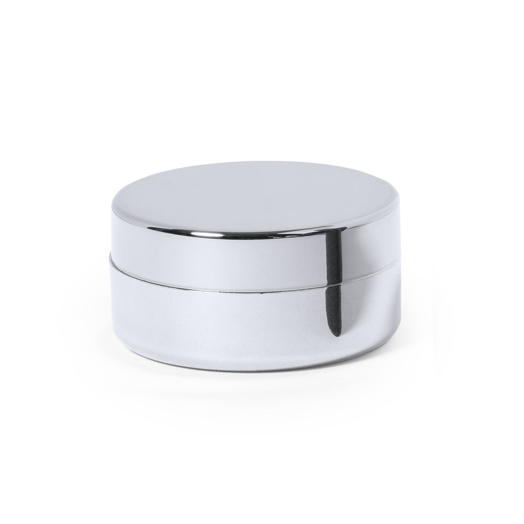 Bálsamo labial dourado metálico com gravação “Vtote”, tampa de rosca e acabamento brilhante, fotografado em fundo neutro de estúdio com luz suave.