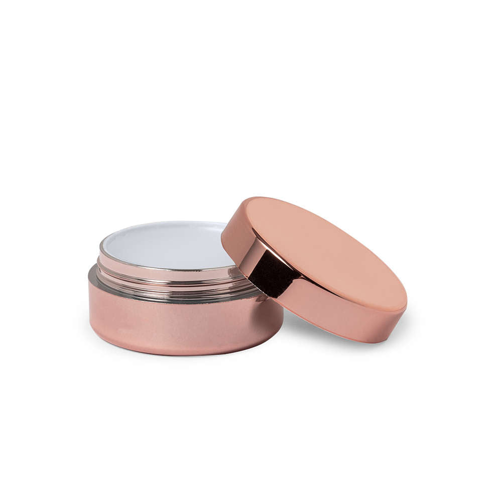 Bálsamo labial dourado metálico com gravação “Vtote”, tampa de rosca e acabamento brilhante, fotografado em fundo neutro de estúdio com luz suave.