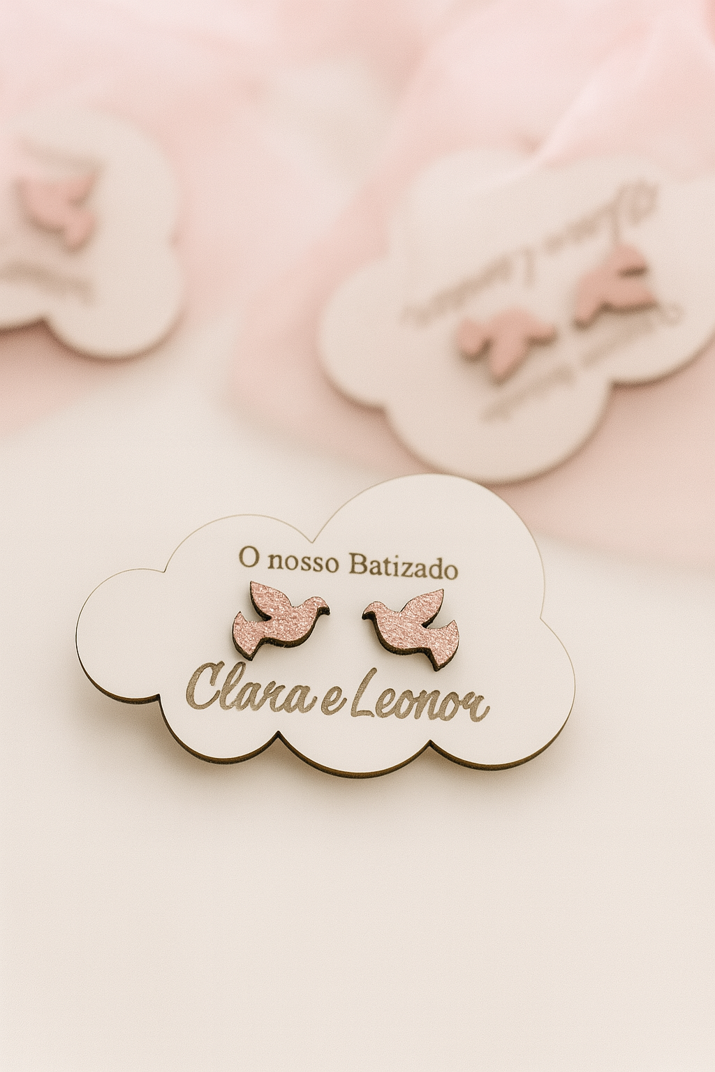 Lembrança de batizado personalizada em madeira com nomes “Clara e Leonor”, pombas em relevo com glitter rosa e base em forma de nuvem.