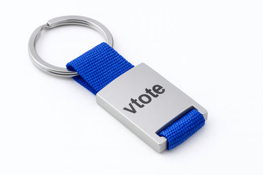 Porta-chaves metálico com fita azul em poliéster e gravação "vtote", ideal para brindes personalizados com gravação laser.