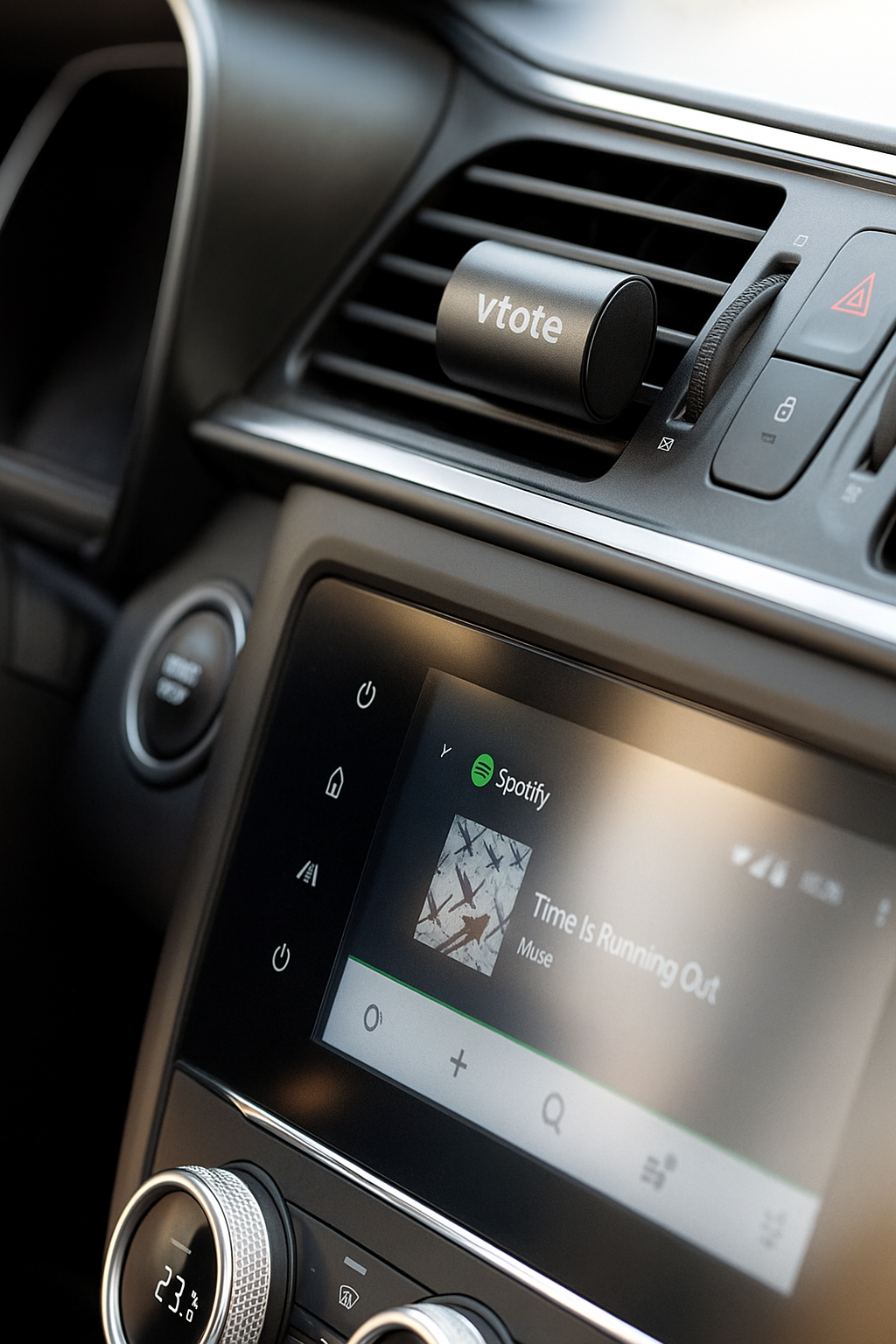 Refrescador de ar para carro fixado na grelha de ventilação, com corpo em alumínio granulado preto e gravação “Vtote”, libertando aroma a limão.