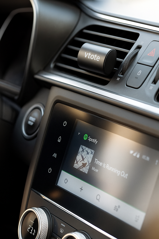 Refrescador de ar para carro fixado na grelha de ventilação, com corpo em alumínio granulado preto e gravação “Vtote”, libertando aroma a limão.